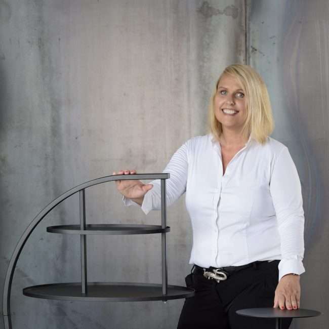 Innenarchitektin Martina Drobny an einem Regal stehend.